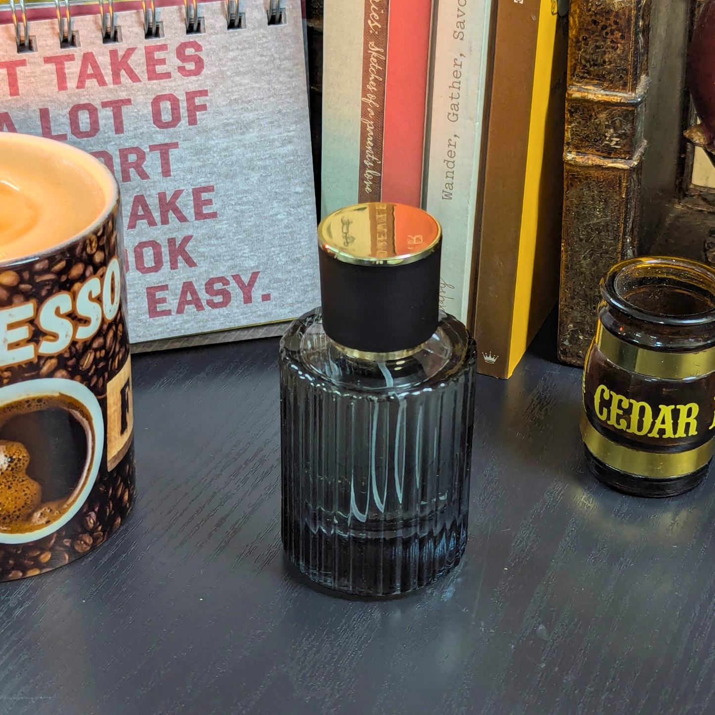 Perfume bottle with a candle and books in the background